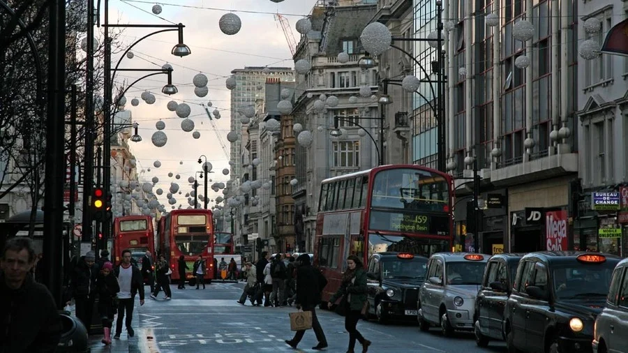 Busy Oxford Street in London with people and red buses