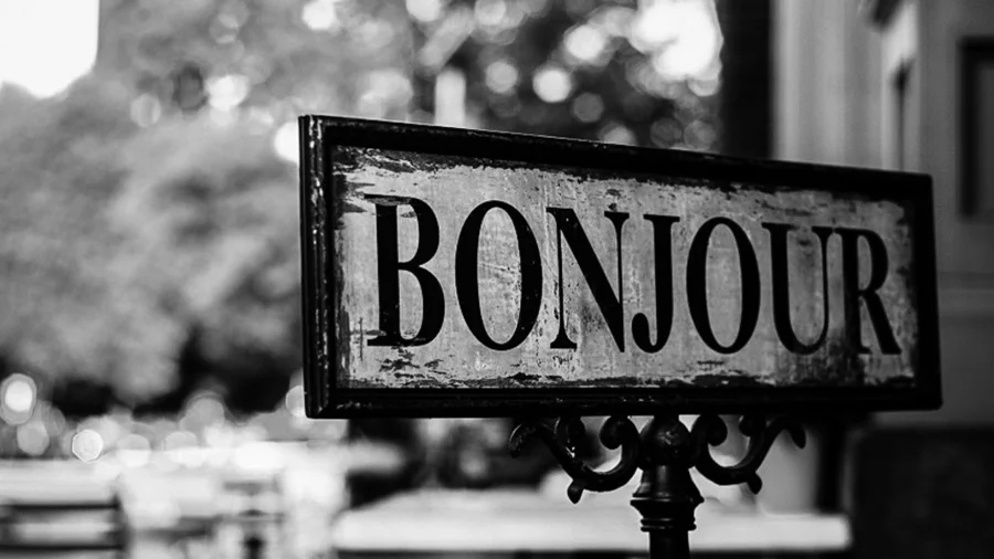 Grayscale image of a Bonjour street sign in Paris