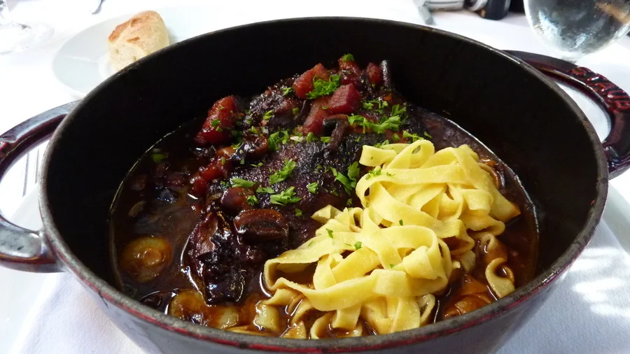 Coq au Vin, a classic French dish, featured in a travel guide to Paris.