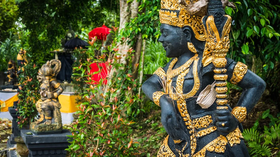 Entrance of a Bali temple with an intricately designed guardian statue, a highlight in Bali travel guide.