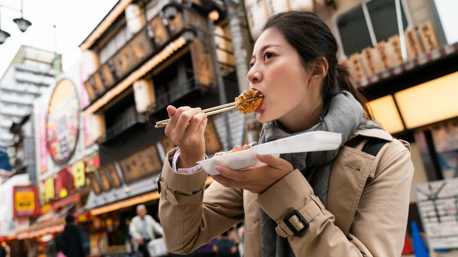 Woman enjoying Takoyaki in Tokyo