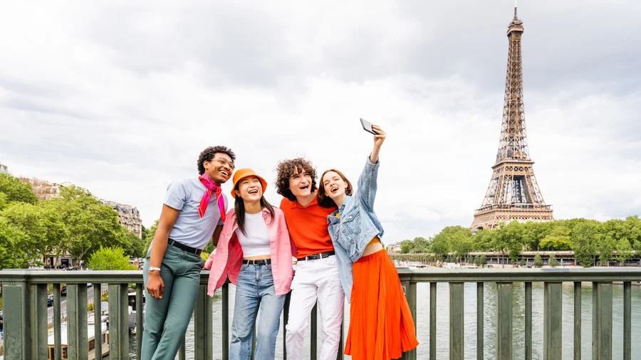 Group of young happy friends in Paris with the Eiffel Tower in the background