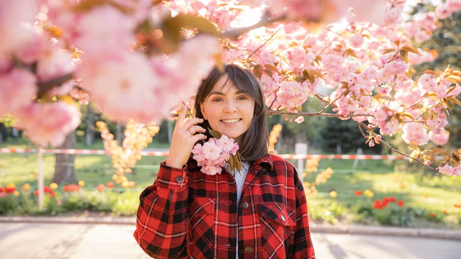 European girl in red jacket with pink cherry blossoms in Japan