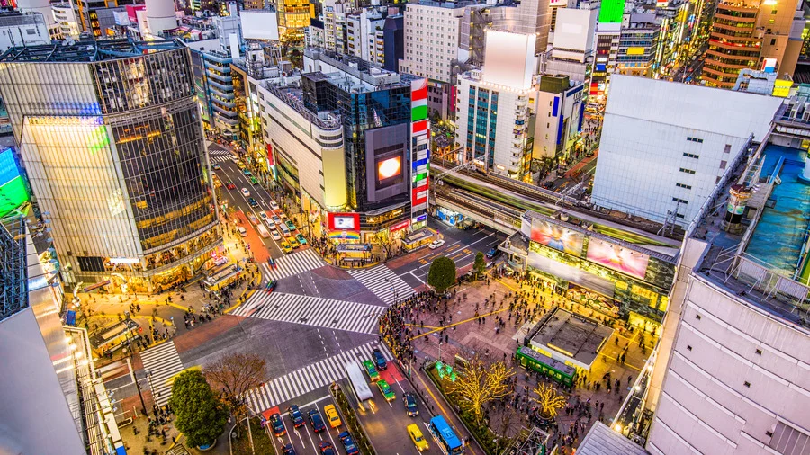 Aerial view of Shibuya Crossing in Tokyo at night, illuminated by vibrant city lights, for Tokyo Travel Guide.