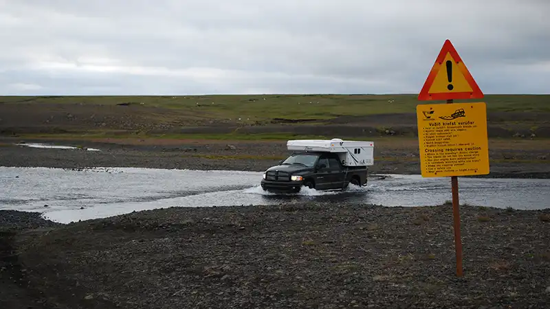 Warning sign near Reykjavik indicating a vehicle crossing a river, essential for a 3-day travel itinerary in Iceland.