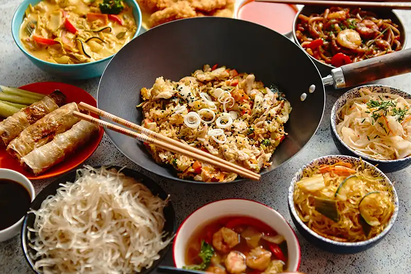 Delicious Chinese Food Set with Dumplings, Noodles, and Stir-Fried Vegetables