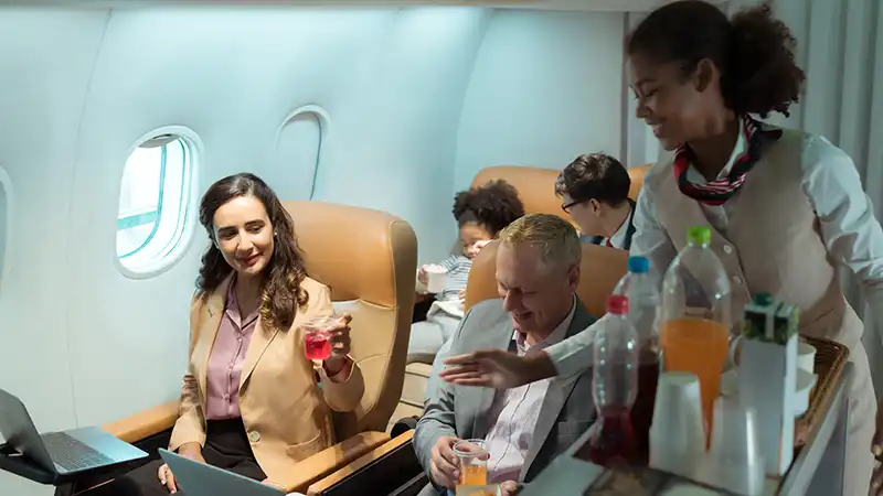 Flight attendant serving food and drinks to passengers during a flight.