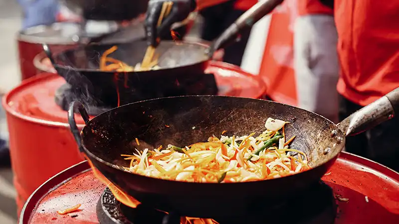 Fried Chinese-Japanese noodles with vegetables and shrimps in a wok.