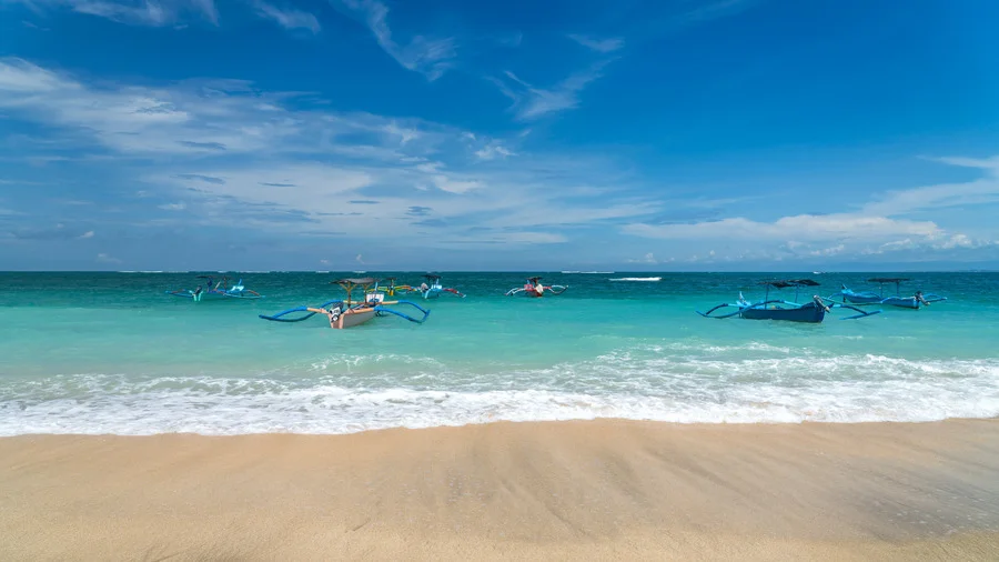 Kuta Beach, a popular destination in Bali Travel Guide, with its stunning white sands and clear waters.