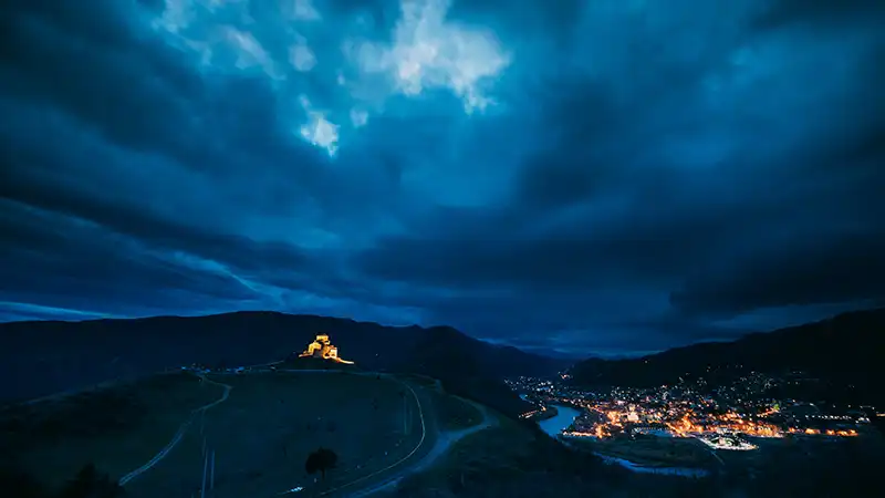 Jvari Monastery in Mtskheta, Georgia under the night sky.