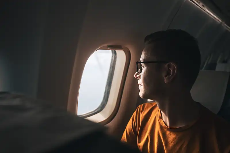 Man traveling by airplane with a neutral expression