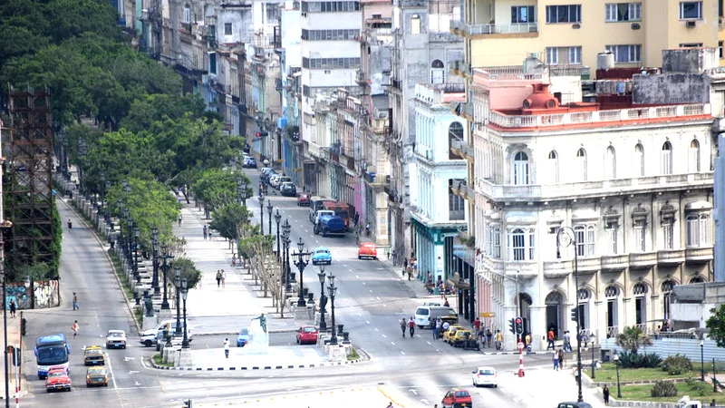 Strolling down Paseo del Prado, Havana's picturesque boulevard lined with trees and vibrant buildings.