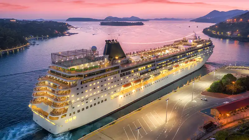 Aerial night view of a cruise ship in port, a popular choice for the best cruise experience for young adults.