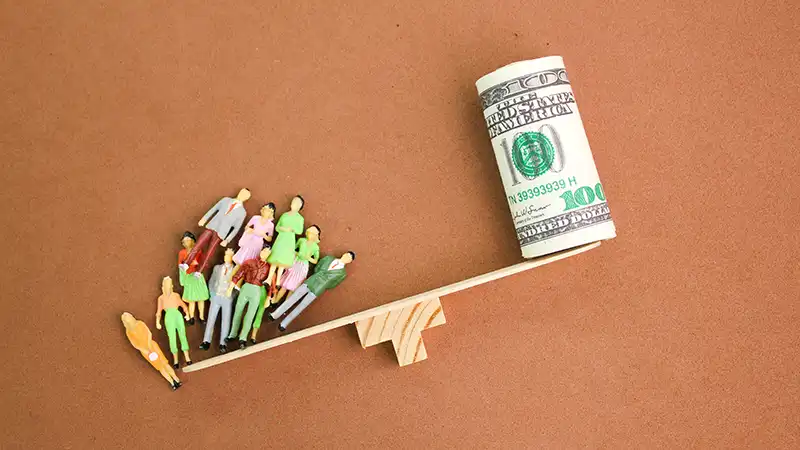 Conceptual image showing the balance between people and money, illustrating the value of human life over financial gain, relevant in discussions about whether travel insurance is necessary.