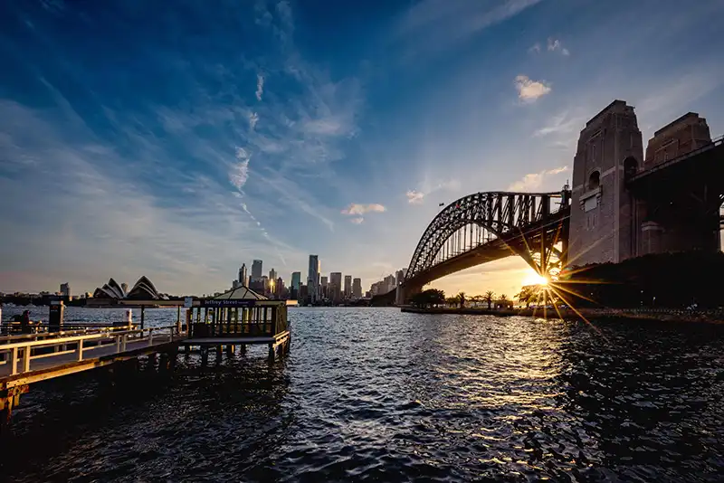 Sunset view of a bridge over water in Sydney, captured in a Sydney travel guide.