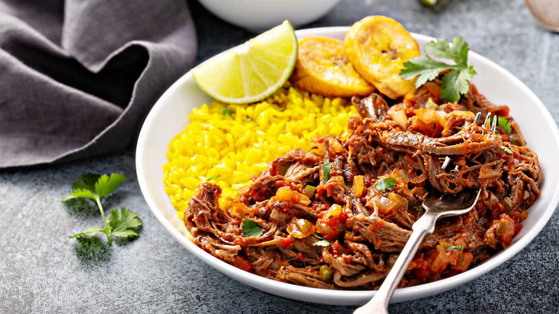 Authentic Ropa Vieja, a traditional Cuban flank steak dish, served with rice - a taste of Havana's rich culinary culture.