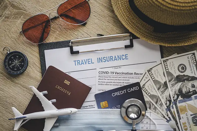 Travel insurance documents on a desk, illustrating the importance of the question: is travel insurance necessary for safe travel?